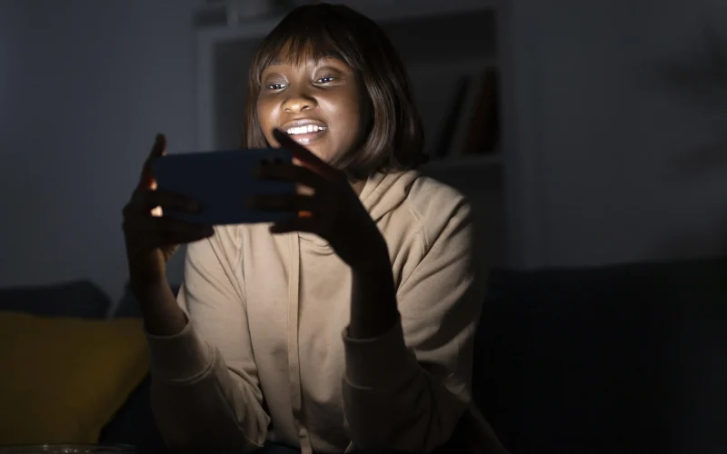 mulher-afro-americana-sorridente-assistindo-servico-de-streaming-em-casa
