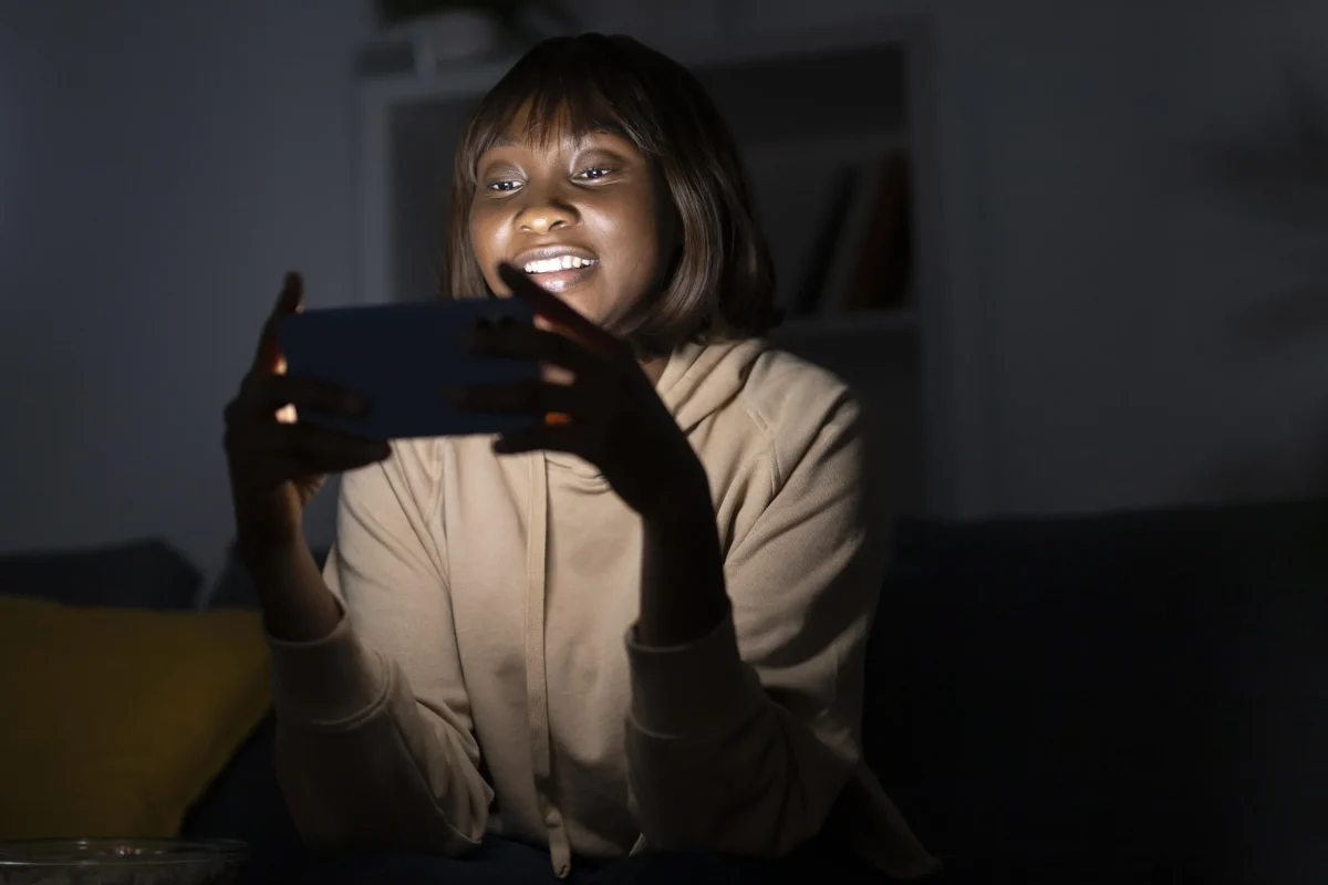 mulher-afro-americana-sorridente-assistindo-servico-de-streaming-em-casa